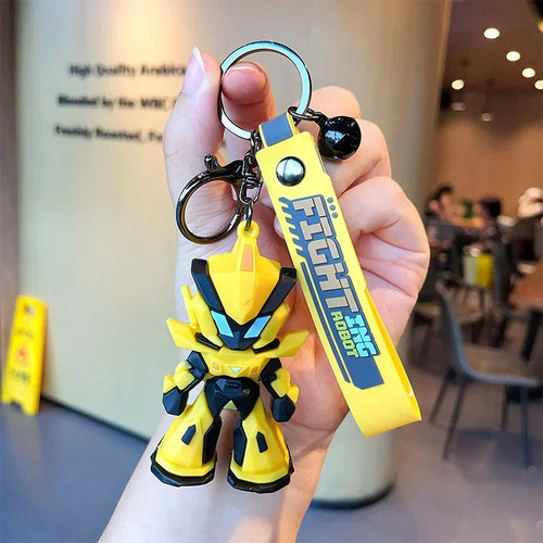 Porte-clés robot jaune stylisé, personnage debout avec porte-clés jaune, intérieur café – Transformers.