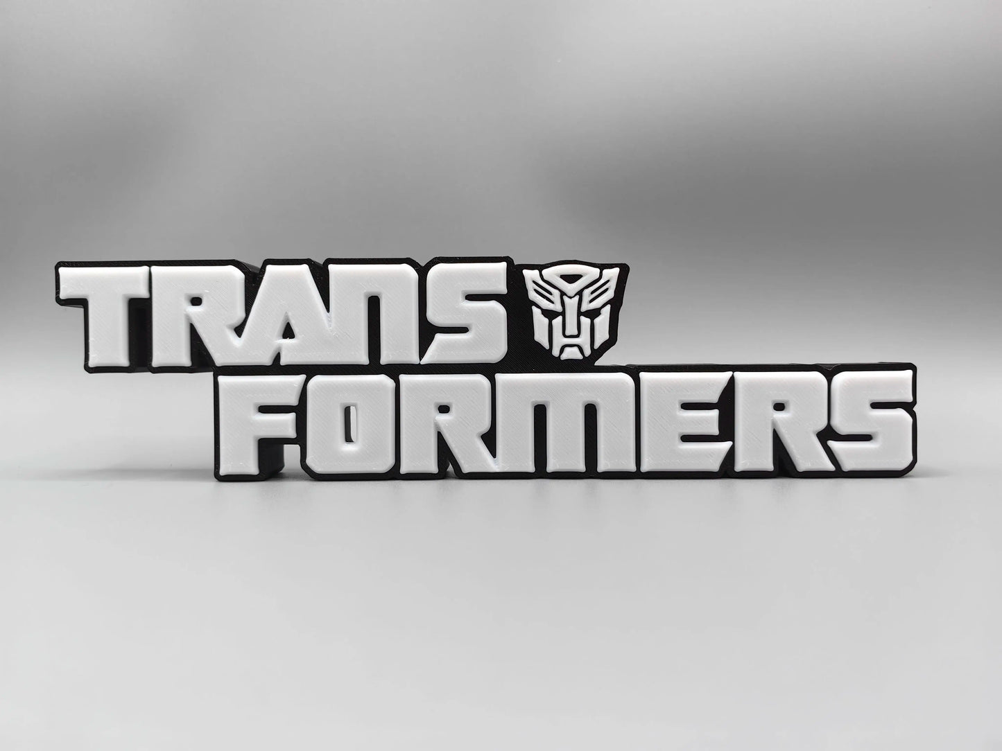 Placa Transformers Logo Plateado Monocromático — Decoración de Escritorio Edición Metalizada