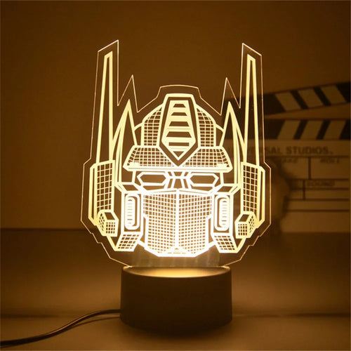 Lampe LED silhouette tête Optimus Prime, lumière jaune sur socle noir, style moderne – Transformers.